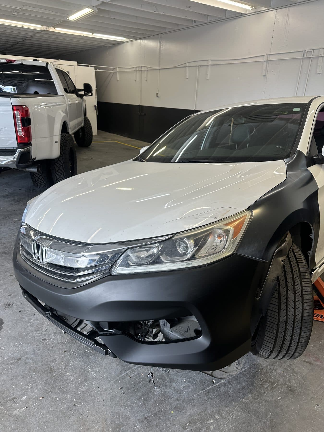 White Honda Accord with a black primered front bumper and fender